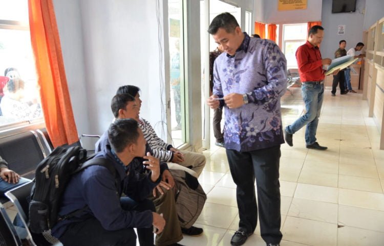 PERLU DITINGKATKAN. Bupati Dendi Ramadhona berbincang dengan warga yang sedang mengurus adminduk di kantor Dinas Kependudukan dan Catatan Sipil (Disdukcapil) Pesawaran, Pesawaran, Kamis (29/8). Pelayanan di kantor Disdukcapil harus terus ditingkatkan. (LAMPUNG POST/PUTRA PANCASILA SAKTI)
