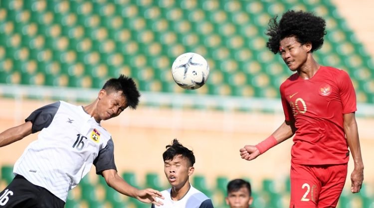 Pesepak bola Indonesia Bagus Kahfi (kanan) berebut bola di udara dengan pesepak bola Laos Channichone (kiri) saat bertanding pada penyisihan Grup A Piala AFF U-18 2019 di Stadion Thong Nhat, Ho Chi Minh, Vietnam, Senin (12/8/2019).  ANTARA FOTO/Yusran Uccang/foc.