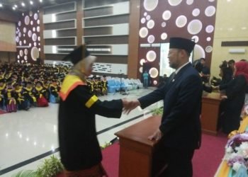 SERAHKAN IJAZAH. Rektor Universitas Terbuka Ojat Dorajat menyerahkan ijazah kepada wisudawan, di Balai Krakatau Bandar Lampung, Kamis (22/8). (ISTIMEWA)