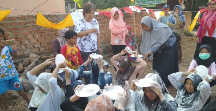 MEMINDAHKAN TEPUNG. Ibu-ibu warga Perumahan Sejahtera RT 08 Dusun III Hajimena, Natar, mengikuti lomba memindahkan tepung di lapangan setempat, Minggu (18/8). Kegiatan digelar dalam rangka memeriahkan HUT ke-74 RI. (LAMPUNG POST/MUHARRAM CANDRA LUGINA)