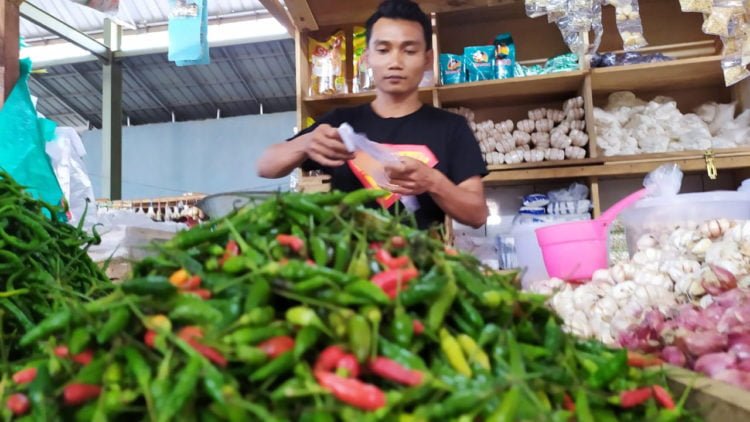 BERTAHAN TINGGI. Salah seorang pedagang cabai rawit di pasar tradisional Sidomulyo, Lampung Selatan, saat melayani pembeli, Selasa (20/8). Harga cabai rawit masih bertahan di angka Rp100 ribu per kilogram. (LAMPUNG POST/PERDHANA WIBYSONO)