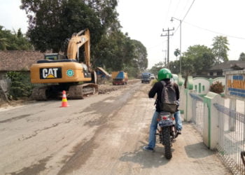 DIPERBAIKI. Alat berat berada di jalan poros Kecamatan Palas, Lampung Selatan, Jumat (27/9). Jalan penghubung antarkabupaten itu yang lama rusak tersebut mulai diperbaiki Pemkab Lamsel. (LAMPUNG POST/ARMANSYAH)