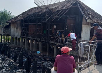 SISA KEBAKARAN. Sejumlah warga melihat sisa rumah yang terbakar di Kampung Kiling-Kiling, Kecamatan Negeribesar, Way Kanan, Senin (9/9). Kejadian yang berlangsung Minggu (8/9), sekitar pukul 23.30 WIB, diduga karena korsleting listrik. (DOKUMENTASI CAMAT NEGERIBESAR)