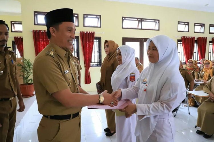 SK PENGANGKATAN. Bupati Lampung Barat Parosil Mabsus menyerahkan secara simbolis 67 SK pengangkatan CPNS dan PTT Dinas Kesehatan di Aula Dinkes setempat, Senin (16/9). (LAMPUNG POST/ELIYAH)