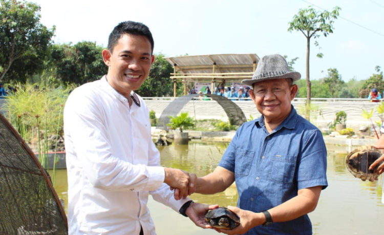 SERAHKAN KURA-KURA. Kepala SMK Muhammadiyah Tumijajar (Mutu) Syamsul Hidayat (kiri) menyerahkan kura-kura kepada Wakil Bupati Tulangbawang Barat Fauzi Hasan untuk ditangkarkan di Taman Bejuqeu Pulungkencana, Jumat (30/8). Hibah tersebut sebagai dukungan SMK Mutu atas pengembangan wisata di Tubaba. (LAMPUNG POST/AHMAD SOBIRIN)