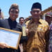 TERBAIK NASIONAL. Managing Director IDeA Indonesia Eko Desriyanto (kiri) memperlihatkan piala dan piagam sebagai Lembaga Pelatihan Terbaik Tingkat Nasional 2019 yang diumumkan pada puncak acara peringatan Hari Aksara Internasional pada 7 September 2019 di lapangan Karebosi, Makassar, Sulawesi Selatan. (DOKUMENTASI IDEA INDONESIA)