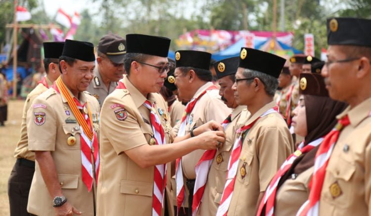 SEMATKAN PENGHARGAAN. Bupati Lampung Timur Zaiful Bokhari menyematkan lencana penghargaan kepada sejumlah anggota Pramuka pada peringatan HUT ke-58 Pramuka di Bumi Perkemahan Desa Srimenanti, Bandarsribahwono, Senin (23/9). (DOKUMENTASI HUMAS PEMKAB LAMTIM)