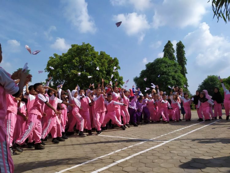 PESAWAT KERTAS. Mengenang BJ Habibie, pelajar PAUD, TK, dan SDN 1 Pasuruan, Kecamatan Penengahan, Lampung Selatan, menggelar upacara bendera dan membuat pesawat dari kertas, Jumat (13/9). LAMPUNG POST/AAN KRIDOLAKSONO