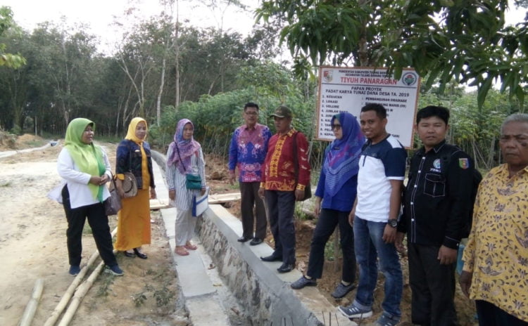 SIRING. Kepalo Tiyuh Panaragan Zaibun (batik merah) bersama sejumlah pengurus desa setempat meninjau hasil pembangunan siring, Minggu (1/9). (LAMPUNG POST/AHMAD SOBIRIN)