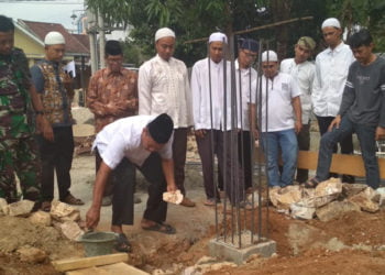 PELETAKAN BATU PERTAMA. Kepala Dusun III Hajimena Man Said disaksikan tokoh agama dan masyarakat melakukan peletakan batu pertama pembangunan Masjid Darul Islah di Perumahan Sejahtera, Hajimena, Jumat (27/9). Dana pembangunan berasal dari sumbangan warga dan donatur. (LAMPUNG POST/MUHARRAM CANDRA LUGINA)