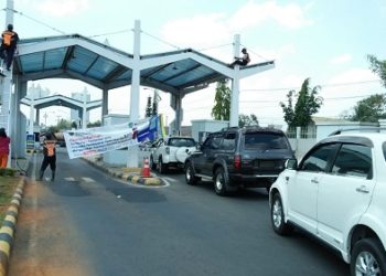 Petugas Bandara Radin Inten II Lampung Selatan memasang banner pemberitahuan pembayaran parkir nontunai bagi pengunjung bandara. Per 1 September 2019, Bandara Radin Inten II menerapkan pembayaran parkir nontunai.
n LAMPUNG POST/CR2