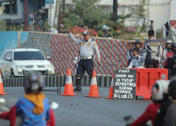 PENGERJAAN MURAL UNDERPASS. Pegawai Dinas Perhubungan Kota Bandar Lampung  berjaga di jalan underpass Unila, Rajabasa, Bandar Lampung, saat dilakukan pelukisan mural, Selasa (17/9). Waktu pengerjaan yang semula 24 jam diubah dari pukul 9 pagi sampai 10 malam.
(LAMPUNG POST/SUKISNO)