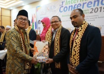 SERAHKAN CENDERA MATA. Rektor UIN Raden Intan Lampung Moh Mukri menyerahkan cendera mata kepada perwakilan perguruan tinggi asing yang hadir saat konferensi internasional, di Hotel Bukit Randu, Bandar Lampung, Selasa (10/9). (LAMPUNG POST/UMAR ROBANI)