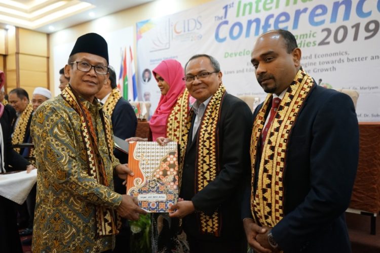 SERAHKAN CENDERA MATA. Rektor UIN Raden Intan Lampung Moh Mukri menyerahkan cendera mata kepada perwakilan perguruan tinggi asing yang hadir saat konferensi internasional, di Hotel Bukit Randu, Bandar Lampung, Selasa (10/9). (LAMPUNG POST/UMAR ROBANI)