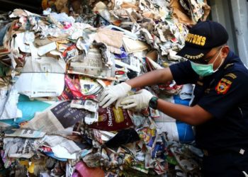 KERTAS BEKAS. Petugas menunjukkan kertas bekas impor yang dikirim dari Australia di lapangan penumpukan kontainer, di PT Terminal Petikemas, baru-baru ini.  (MI)