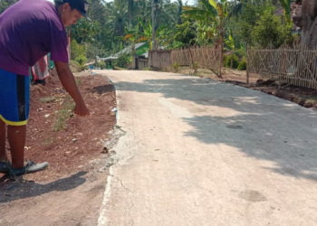 SUDAH RUSAK. Salah seorang warga menunjukkan kerusakan jalan cor di Desa Banjarsuri, Kecamatan Sidomulyo, Lampung Selatan. Padahal, jalan tersbeut belum lama dibangun dengan menggunakan dana desa.(LAMPUNG POST/PERDHANA WIBYSONO)