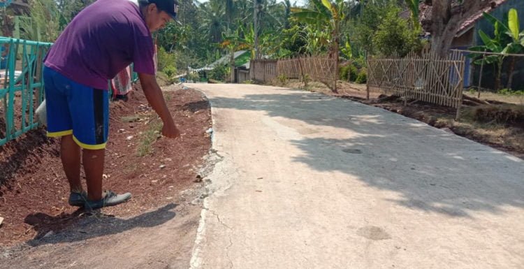 SUDAH RUSAK. Salah seorang warga menunjukkan kerusakan jalan cor di Desa Banjarsuri, Kecamatan Sidomulyo, Lampung Selatan. Padahal, jalan tersbeut belum lama dibangun dengan menggunakan dana desa.(LAMPUNG POST/PERDHANA WIBYSONO)