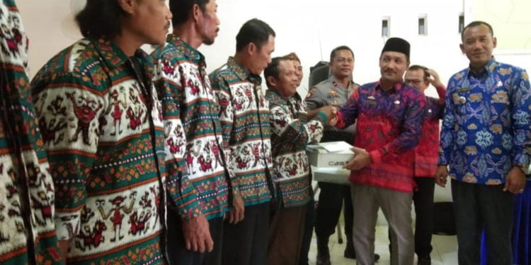 BERIKAN PENGHARGAAN. Kepala Desa Margajasa, Kecamatan Sragi, Lampung Selatan, Alex Sansu disaksikan Camat Sragi Bibit Purwanto saat memberikan penghargaan kepada petugas PBB di kantor desa setempat, Jumat (20/9). (LAMPUNG POST/ARMANSYAH)