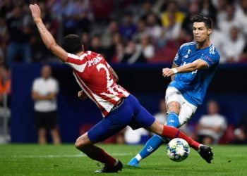 TENDANG BOLA. Pemain depan Juventus, Cristiano Ronaldo (kanan) menendang bola yang coba dihadang bek Atletico Madrid, Jose Gimenez pada laga perdana babak grup Liga Champions di Stadion Wanda Metropolitano, Kamis (19/9) dini hari WIB.(AFP/OSCAR DEL POZO)