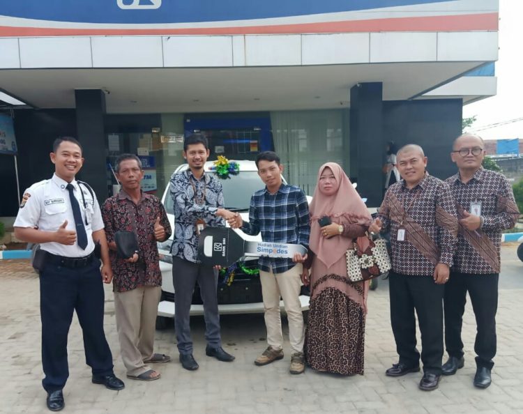 SERAHKAN HADIAH. Kepala Cabang (Kacab) BRI Cabang Tulangbawang, Fajar Arief Wibowo, menyerahkan hadiah utama secara simbolis kepada Rudi Andrianto di halaman kantor BRI setempat, Kamis (17/10). LAMPUNG POST/RIAN PRANATA
