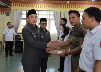 SERAHKAN SK. Bupati Lampung Barat Parosil Mabsus menyerahkan SK pengangkatan pegawai tidak tetap (PTT) Lampung Barat, Rabu (23/10). DOK PEMKAB LAMBAR