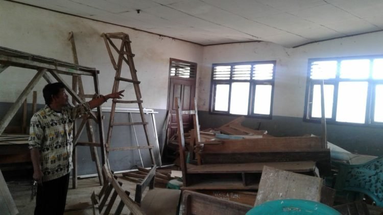 RUANG KELAS. Penjaga sekolah SDN 1 Cempaka, Desa Cempaka, Kecamatan Sungkaijaya, menunjukkan siku penyangga di ruang kelas, Selasa (1/10)). LAMPUNG POST/YUDHI HARDIYANTO