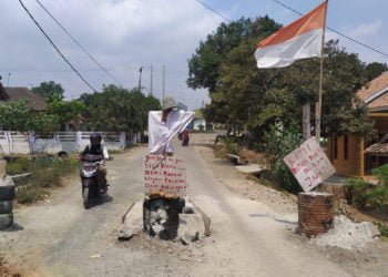 BELUM DIBUKA. Jalan di Desa Tanjungan, Kecamatan Katibung, Lampung Selatan, masih diblokir warga, Selasa (8/10). Warga kesal karena hanya diberi janji manis terkait perbaikan jalan tersebut. (LAMPUNG POST/PERDHANA WIBYSONO)