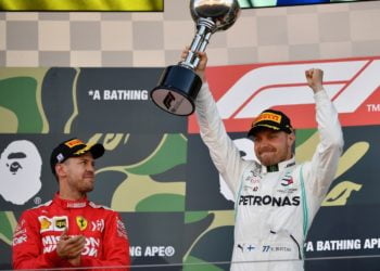 ANGKAT TROFI. Pembalap Mercedes, Valtteri Bottas (kanan) mengangkat trofi untuk merayakan kemenangannya di samping pembalap Ferrari yang berada di tempat kedua, Sebastian Vettel di podium setelah Grand Prix Jepang Formula Satu di Suzuka, Minggu (13/10).(AFP/TOSHIFUMI KITAMURA)