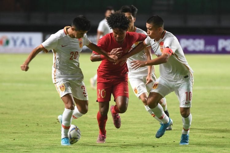 BEREBUT BOLA. Pemain Timnas Indonesia U-19 Amiruddin Bagus Kahfi (tengah) berebut bola dengan pemain Tiongkok U-19 Mohemaiti Naibijiang (kanan) dan Aisikaer Aifeierding (kiri) saat laga uji coba di Gelora Bung Tomo, Surabaya, Jawa Timur, Kamis (17/10). Indonesia menang atas Tiongkok dengan skor 3-1.(ANTARA FOTO/ZABUR KARURU)