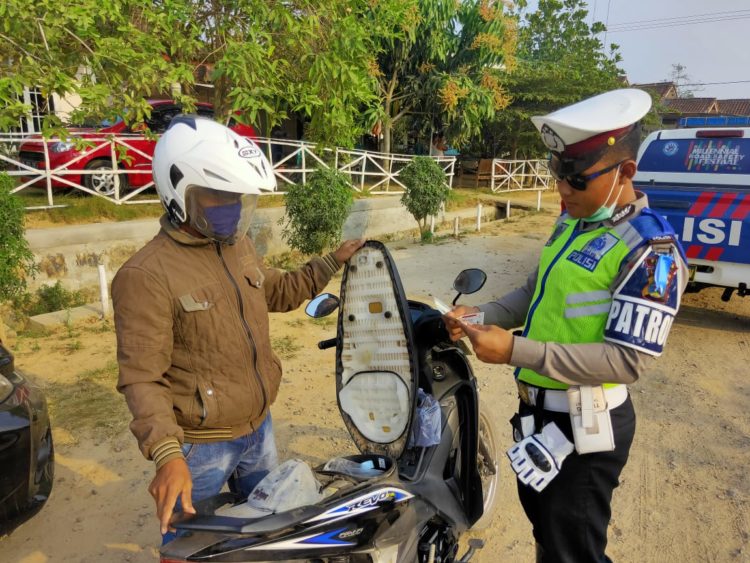 PERIKSA SURAT. Petugas Satuan Lalu Lintas (Satlantas) Polres Mesuji memeriksa surat-surat kelengkapan pengendara motor. DOK POLRES MESUJI
