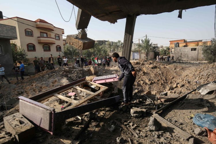 CARI SISA BARANG. Seorang pria Palestina mencari barang-barang yang bisa diselamatkan di tengah puing-puing rumah yang hancur dalam serangan udara Israel di Khan Yunis, Jalur Gaza selatan, Rabu (13/11). (SAID KHATIB/AFP)