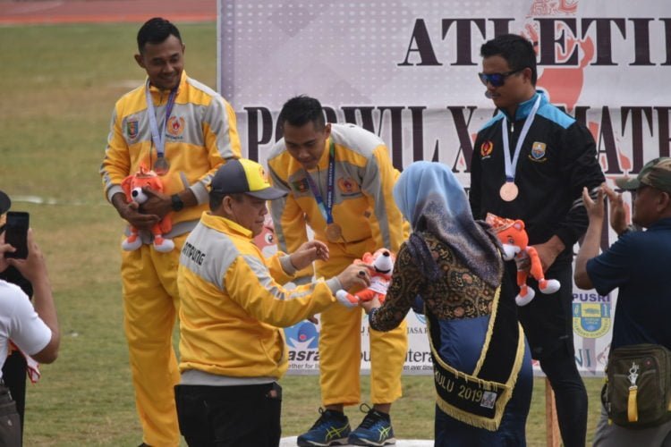 EMAS DAN PERAK. Eko Wicaksono saat menerima pengalungan medali usai menyabet emas nomor lompat galah atletik Pekan Olahraga Wilayah (Porwil) X Sumatera di Stadion Semarak Sawah Lebar, Bengkulu, Rabu (6/11). Rekan sedaerahnya Hendri Setiawan merebut perak. (DOK. HUMAS KONI LAMPUNG)
