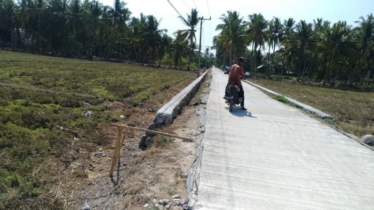 MENUAI PROTES. Pembangunan jalan rabat beton ruas Way Sidomukti—SMKN 1 Ketapang di Desa Berundung, Kecamatan Ketapang, Lamsel yang belum tuntas menuai protes warga setempat, Minggu (17/11). LAMPUNG POST/AAN KRIDOLAKSONO