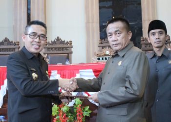 TERIMA NASKAH. Bupati Lampung Timur Zaiful Bokhari menerima naskah APBD 2020 yang baru disahkan DPRD setempat, Kamis (28/11). Naskah tersebut diserahkan Ketua DPRD Lampung Timur Ali Johan Arif. LAMPUNG POST/DJONI HARTAWAN JAYA