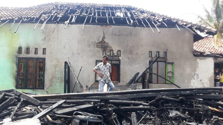 RUMAH TERBAKAR. Ridwan, korban kebakaran, meratapi puing-puing rumahnya yang habis terbakar, Senin (11/11). LAMPUNG POST/FERDI IRWANDA