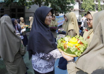 SAMBUT HARI GURU. Sejumlah siswa SMP Muhammadiyah 5 Solo memberikan roti, nasi tumpeng, dan bunga kepada guru-guru mereka saat acara menyambut Hari Guru Nasional yang diperingati setiap 25 November di halaman sekolah setempat, Solo, Jawa Tengah, Jumat (22/11). (ANTARA/MAULANA SURYA)
