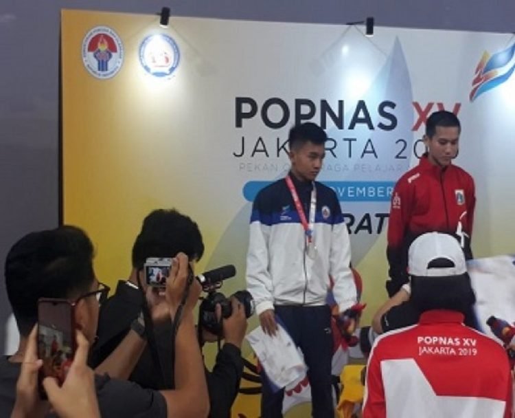 RAIH PERAK. Karateka Andika Hulio Pratama yang turun di nomor kumite kelas -50 kg putra meraih medali perak usai kalah dari karateka DKI Jakarta pada ajang Popnas XV Jakarta di GOR Remaja Cempaka Putih, Selasa (19/11).(DOK DISPORA LAMPUNG)