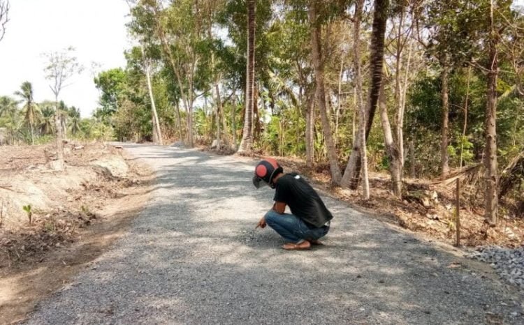 Warga saat menunjukkan titik bagian yang terkelupas pada proyek peningkatan ruas Jalan Margajasa—Lebunggalih, Lampung Selatan, Minggu, (17/11) Armansyah