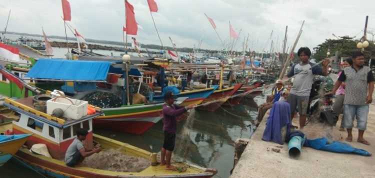 Sejumlah nelayan yang berdandar di Dermaga Bom Kalianda, Lampung Selatan, saat memperbaiki jaring, Minggu (3/11/2019). Armansyah