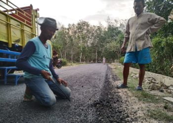 Warga Dusun 3, Desa Sabahbalau, melakukan pengukuran jalan yang diduga asal jadi, Jumat(22/11). SUKISNO