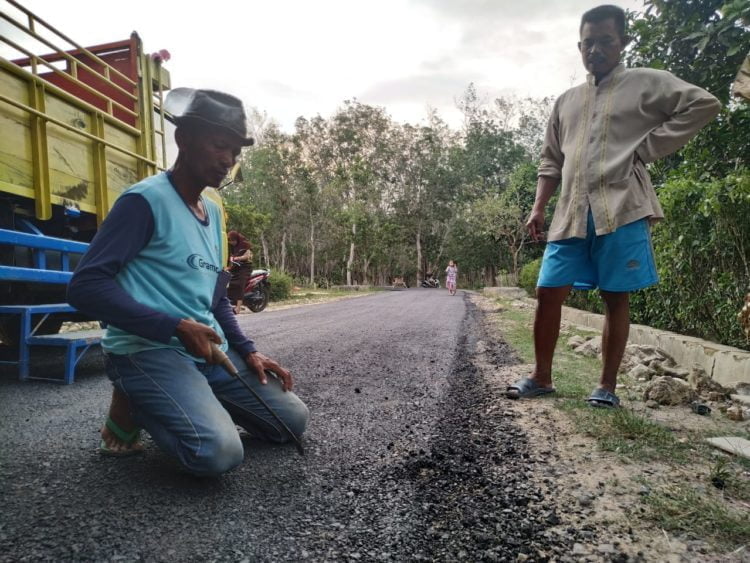 Warga Dusun 3, Desa Sabahbalau, melakukan pengukuran jalan yang diduga asal jadi, Jumat(22/11). SUKISNO