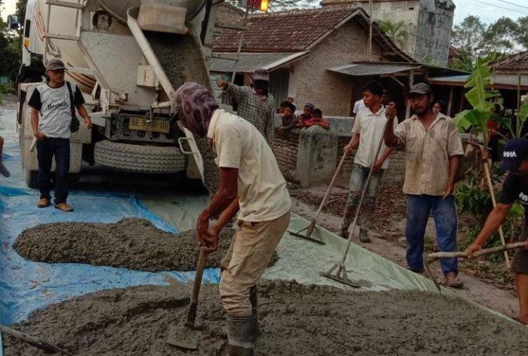 PROYEK BAKTIRASA. Para pekerja saat menggelar ready mix pada proyek pembangunan jalan rabat beton di ruas Jalan Desa Baktirasa-Kedaung, Kecamatan Sragi, Lampung Selatan, Jumat (13/12). LAMPUNG POST/ARMANSYAH