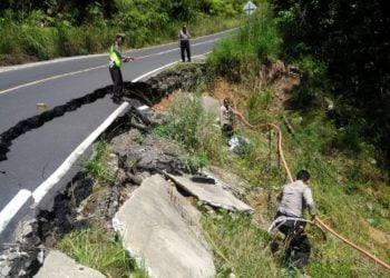 PASANG GARIS. Polsek Pesisir Utara memasang garis polisi di jalan yang ambles di lintas Krui—Bengkulu. DOK POLSEK PESISIR UTARA