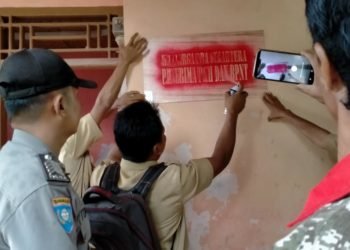 LABELISASI. Aparatur Desa Mandalasari, Kecamatan Sragi, Lampung Selatan, didampingi pendamping PKH, bhabinkabtimas, dan babinsa, saat melakukan labelisasi tanda khusus di rumah KPM PKH, di desa setempat, Senin (16/12). LAMPUNG POST/ARMANSYAH