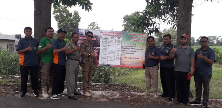 PASANG IMBAUAN. Petugas gabungan Satpol PP dan Dinas Lingkungan Hidup memasang tanda larangan membuang sampah sebarangan berikut sanksinya, Selasa (17/12). DOK DLH METRO