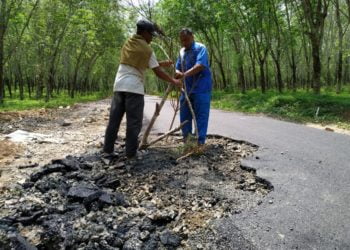 PASANG RAMBU. Warga tengah memasang rambu-rambu berupa kayu di jalan rusak di Desa Sabahbalau Kecamatan Tanjungbintang Lampung Selatan, Rabu (11/12). n LAMPUNG POST/SUKISNO
