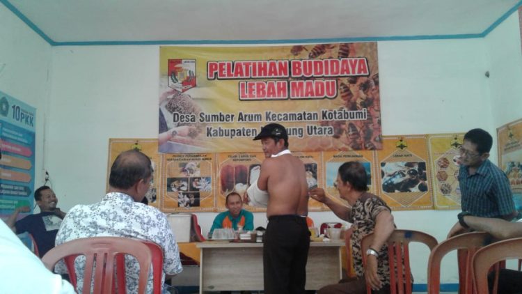 TERAPI LEBAH. Instruktur Pusat Apiari Pramuka Bidang Perlebahan, Sudharto, mempraktikkan terapi sengatan lebah pada peserta saat pelatihan budi daya lebah madu di aula Balai Desa Sumberarum, Kecamatan Kotabumi, Lampung Utara, Sabtu (21/12). LAMPUNG POST/YUDHI HARDIYANTO