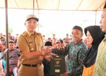 BAGIKAN SERTIFIKAT. Bupati Lambar Parosil Mabsus membagikan sertifikat tanah program PTSL, Senin (30/12). n DOKUMENTASI PEMKAB LAMBAR
