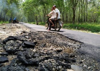 JALAN RUSAK. Pengendara motor melintasi jalan Dusun 2, Desa Sabahbalau, Kecamatan Tanjungbintang, Lampung Selatan, yang rusak beberapa waktu lalu. DOK LAMPUNG POST