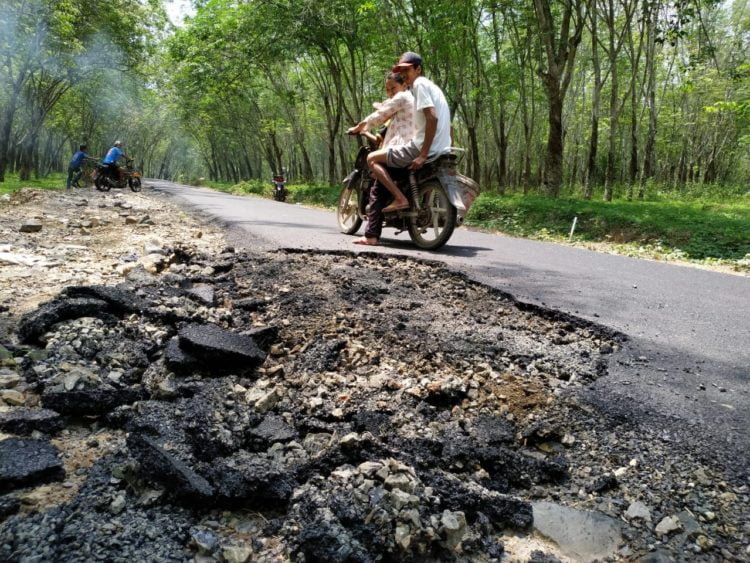 JALAN RUSAK. Pengendara motor melintasi jalan Dusun 2, Desa Sabahbalau, Kecamatan Tanjungbintang, Lampung Selatan, yang rusak beberapa waktu lalu. DOK LAMPUNG POST